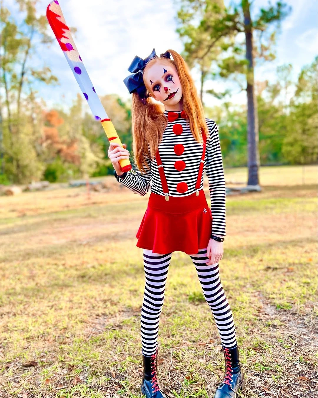 Girl in striped doll costume with red skirt and blue bow