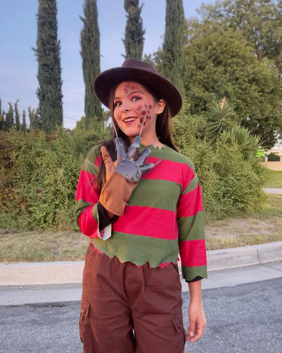 Girl in striped sweater brown hat and scar makeup costume