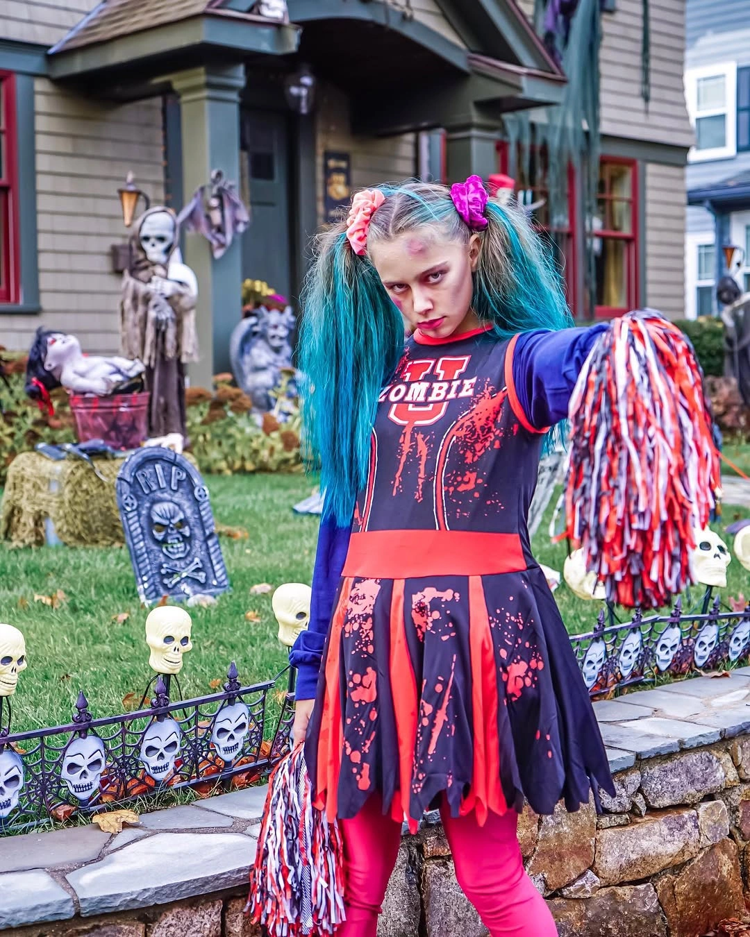 Girl in purple pink zombie cheerleader costume with blue pigtails