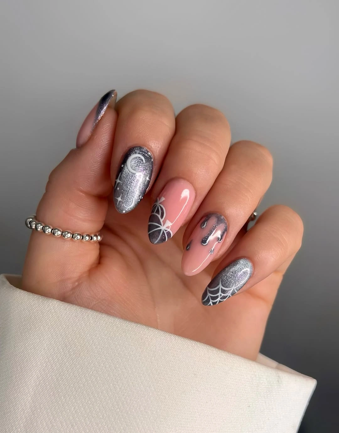 Soft pink almond nails with chrome web and black French tips