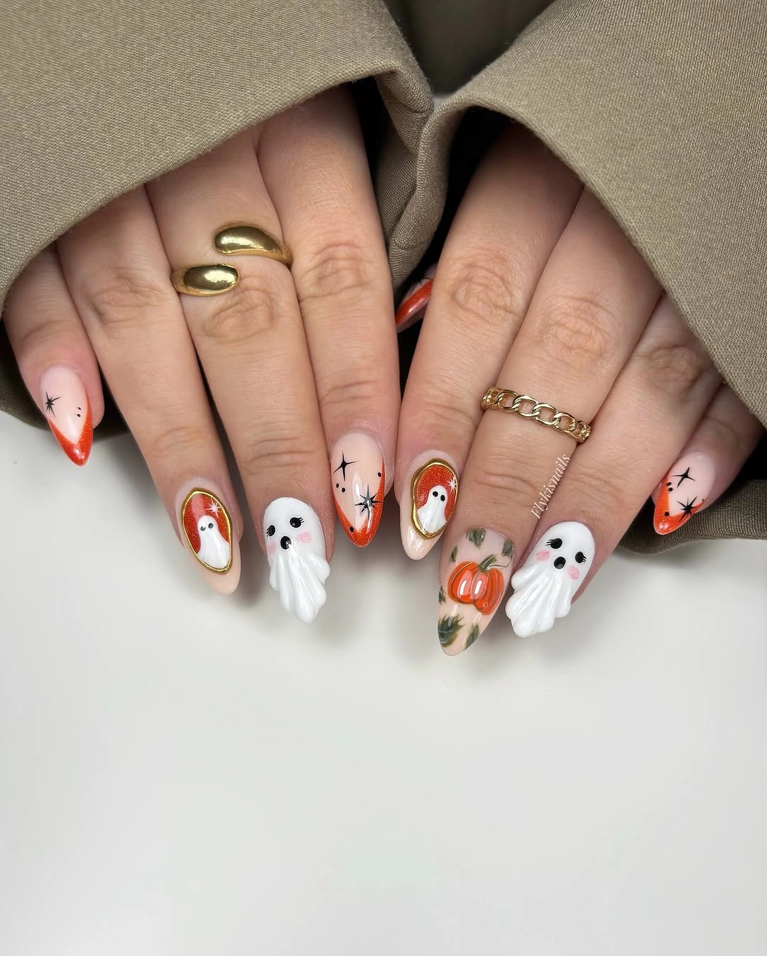 Short rounded peach nails with ghosts pumpkins stars and orange edges