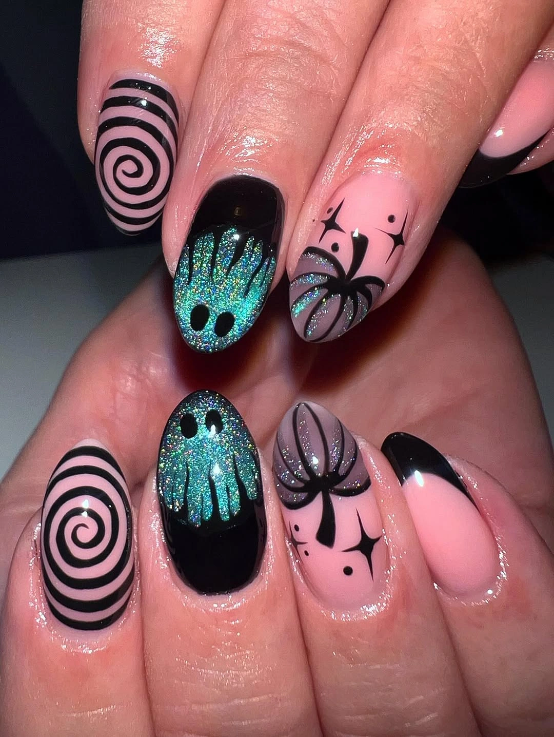 Short pink nails with black spirals and blue glitter ghosts