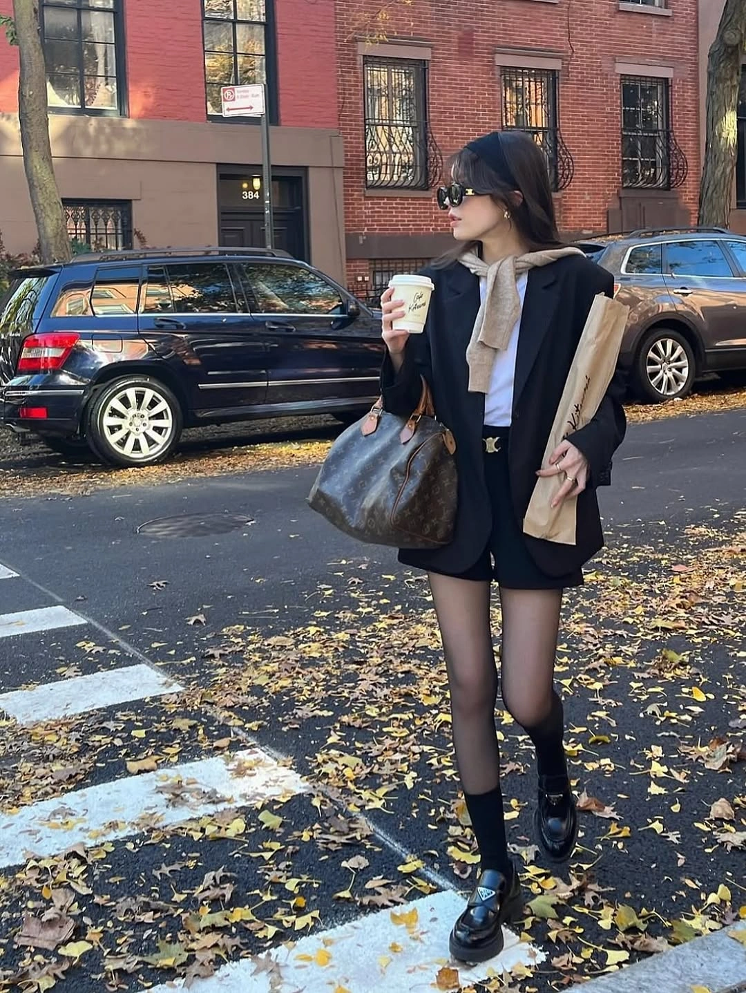Black jacket beige neck tie sheer tights and loafers