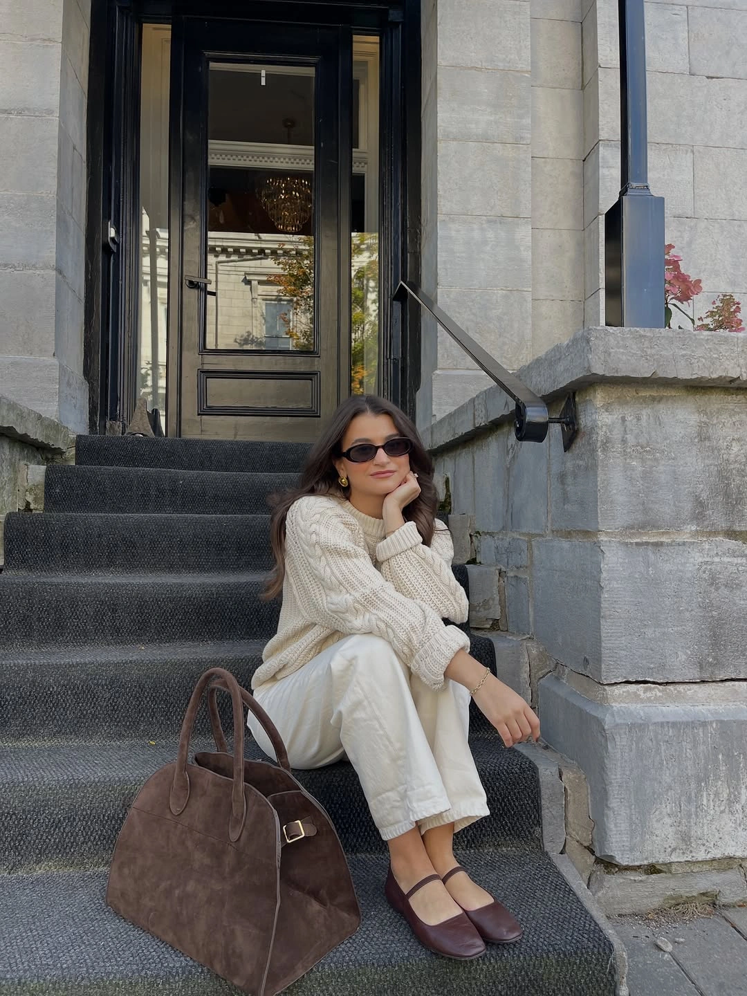 Cream cable-textured sweater with pale pants and brown flats