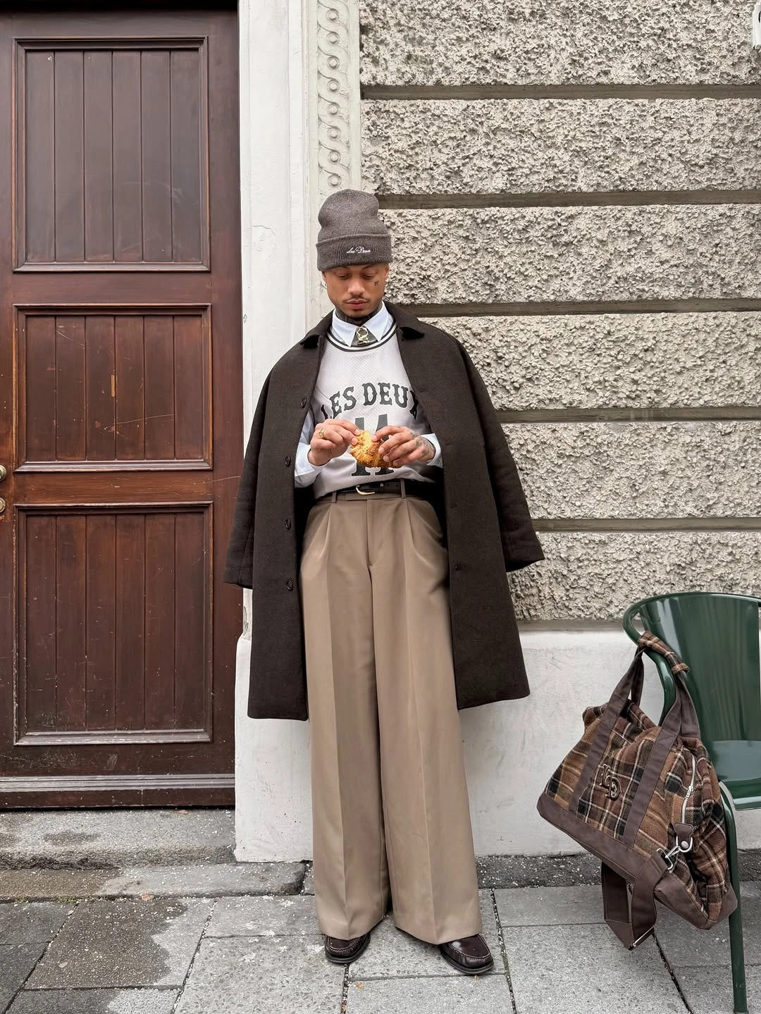 Long brown coat over graphic cream top and wide beige trousers