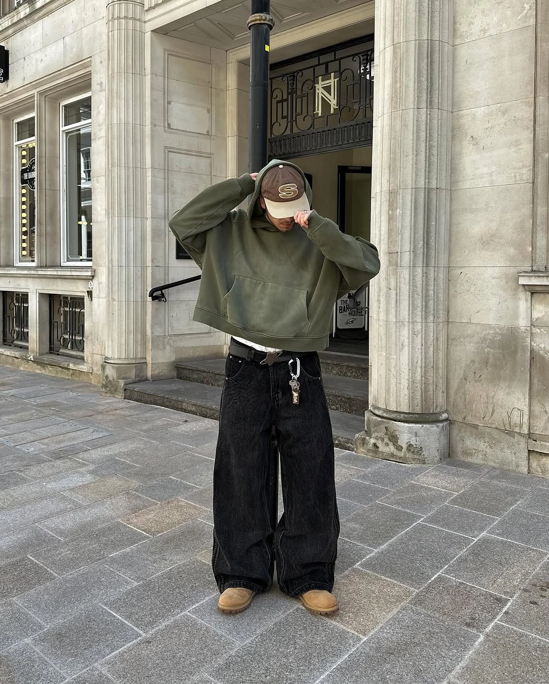 Olive oversized sweatshirt with wide black trousers and tan shoes