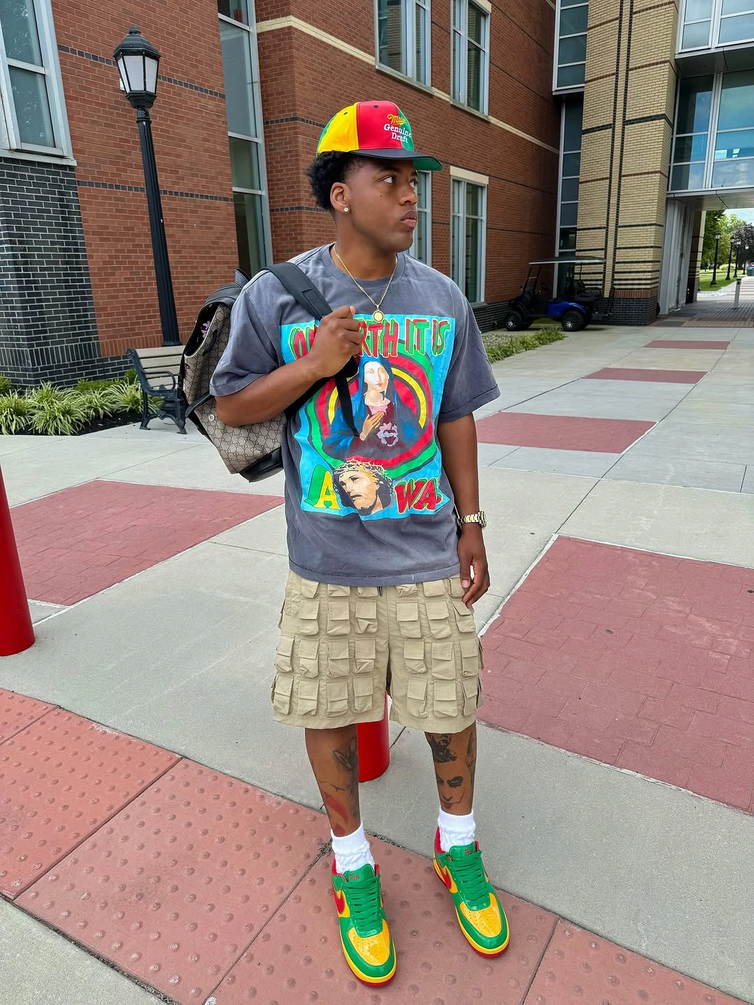 Graphic T-shirt with beige cargo shorts, cap, and colorful sneakers