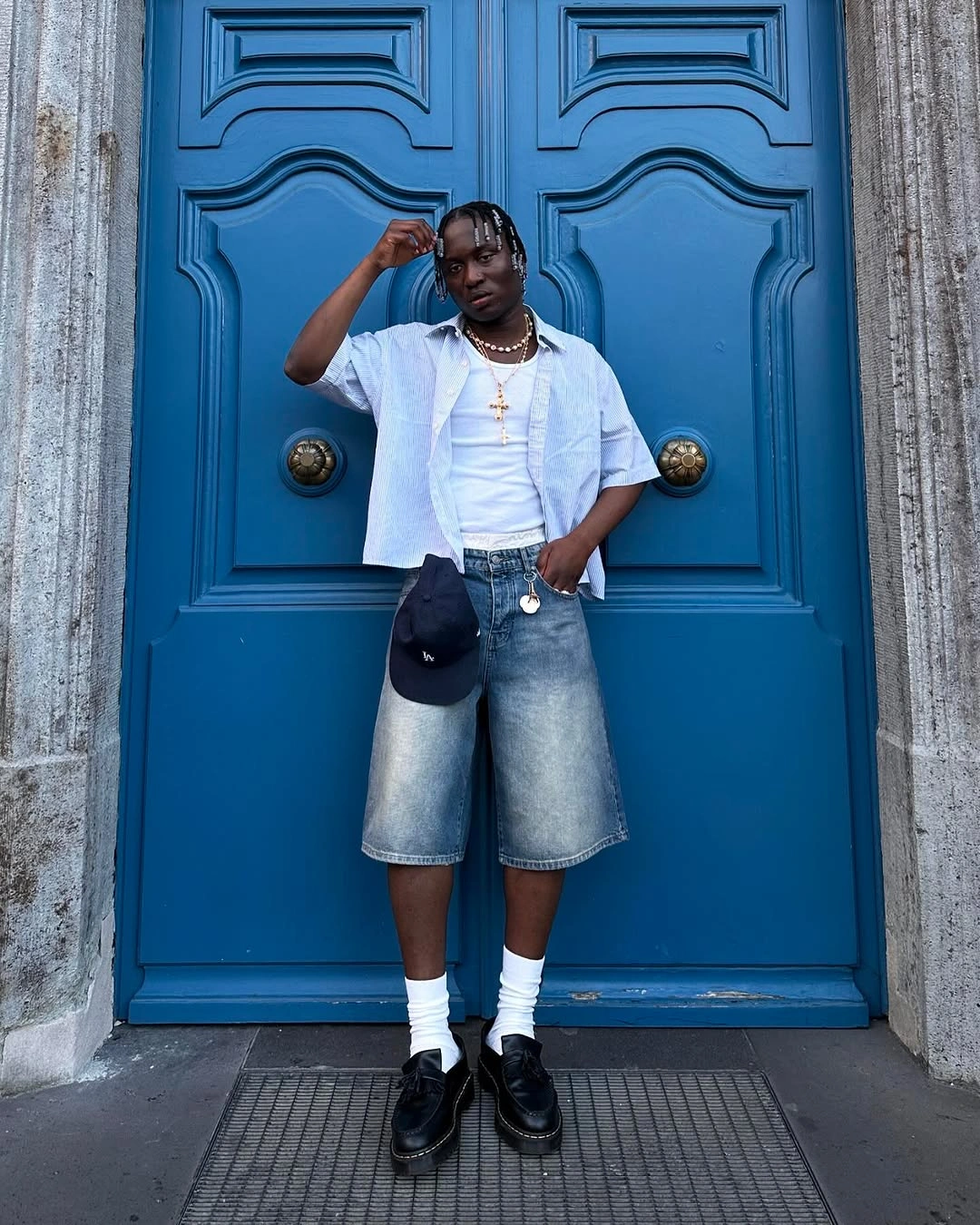 White short-sleeve shirt with denim shorts, loafers, and white socks