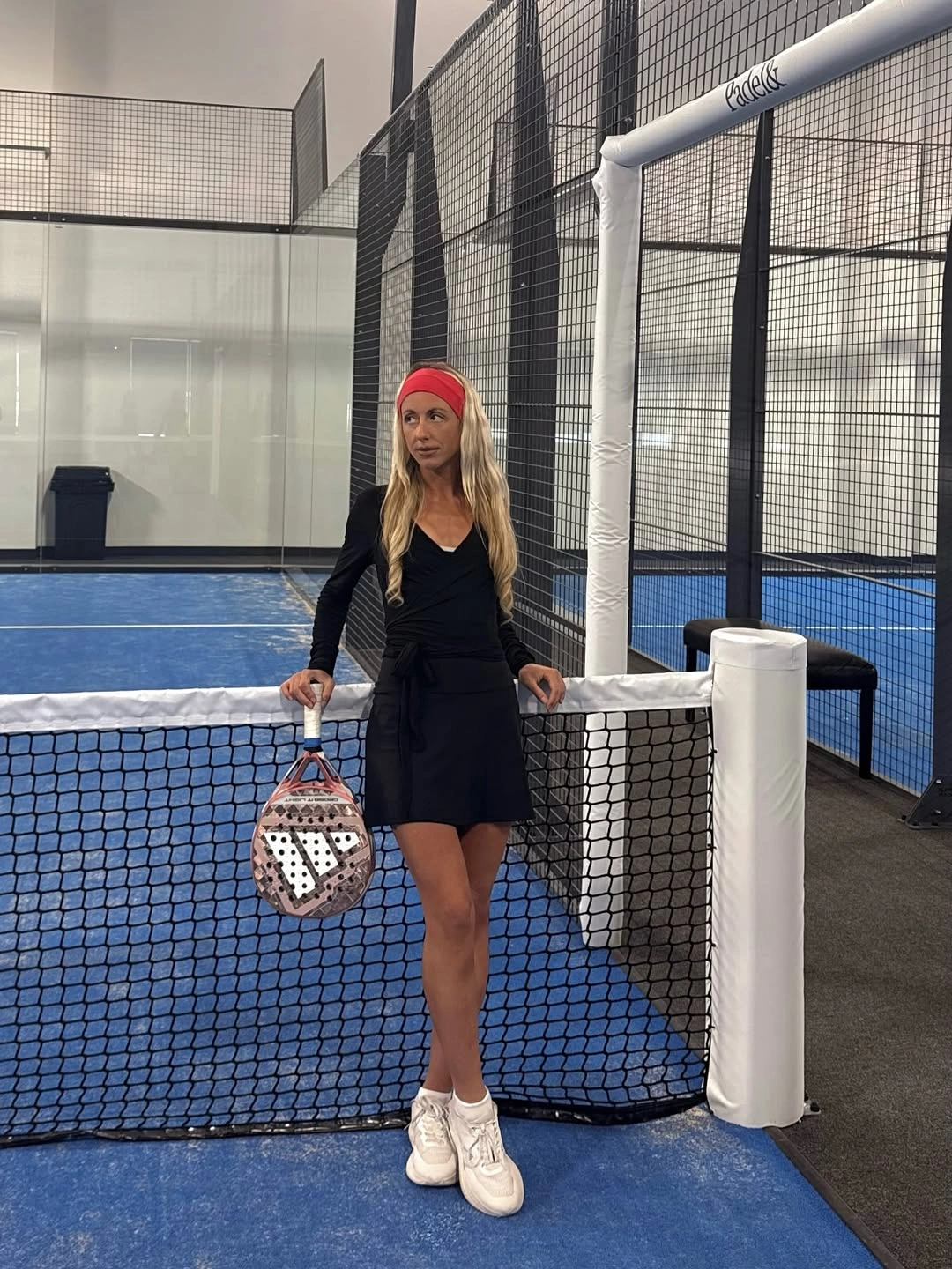 Black long-sleeve padel dress with red headband and white shoes