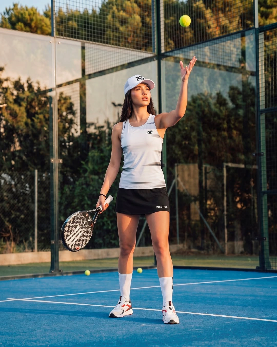White tank and black skirt with white cap for padel