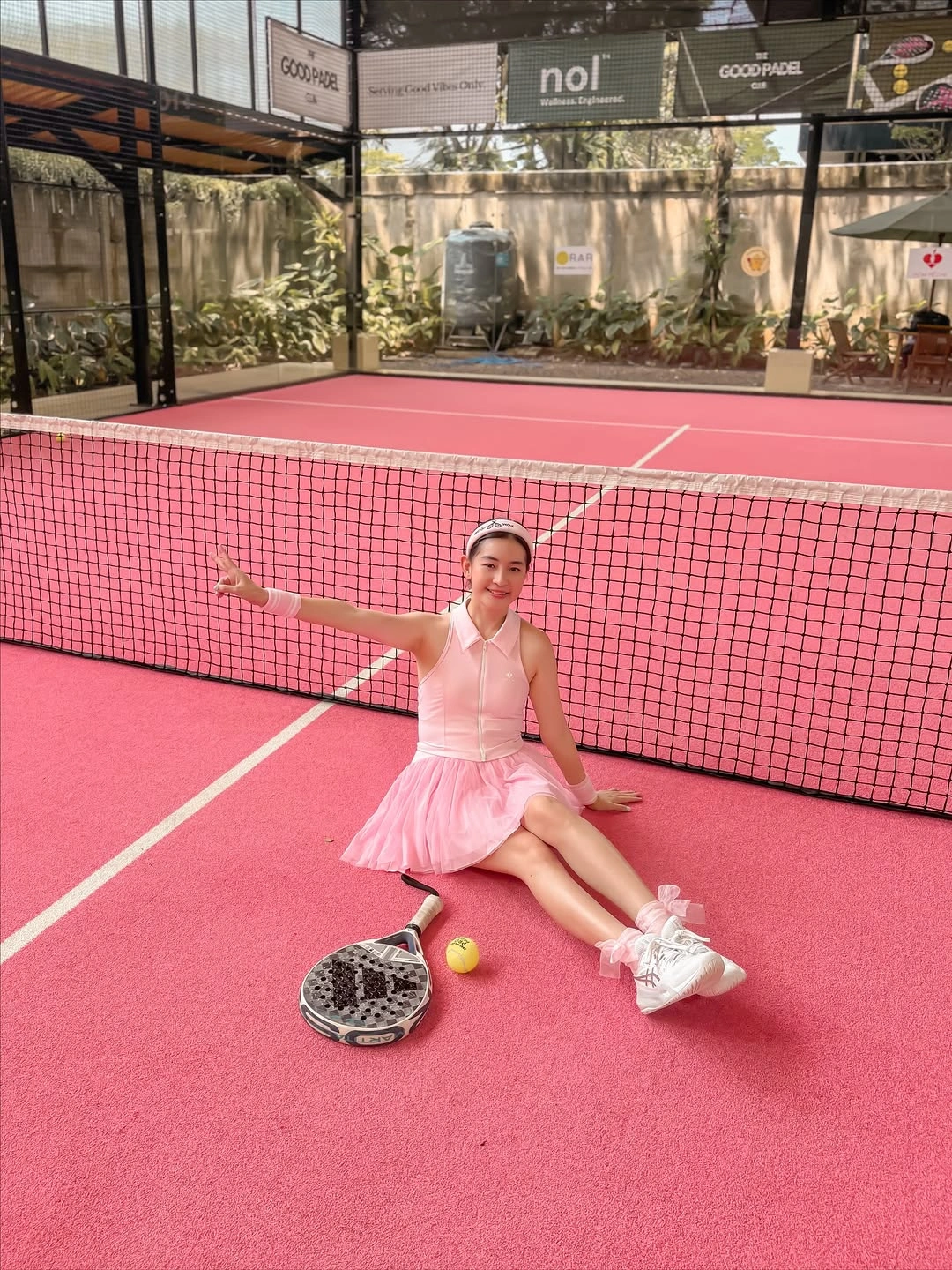Pale pink athletic tank and pleated skirt with white sneakers