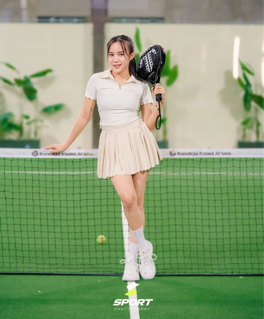 Cream polo with pleated cream skirt and white footwear for padel