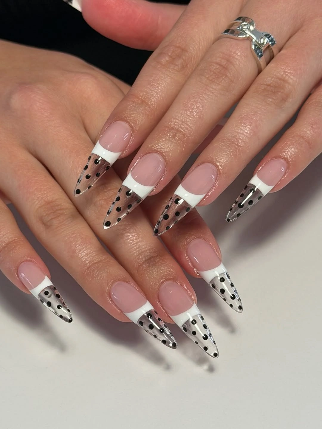 pointed nails with white French tips and black polka dots
