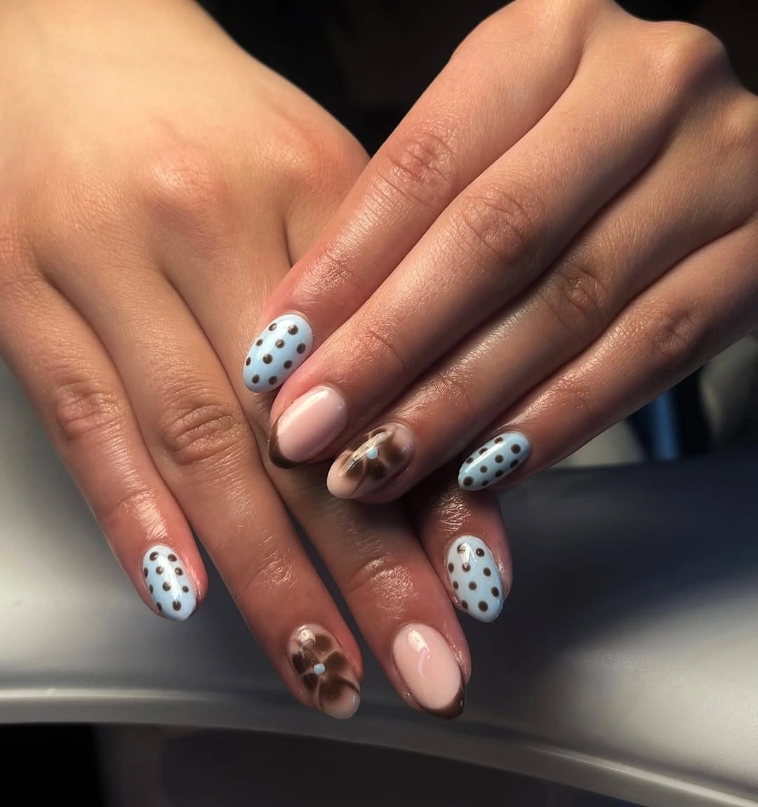 pale blue and nude nails with black polka dots and cocoa brown accent
