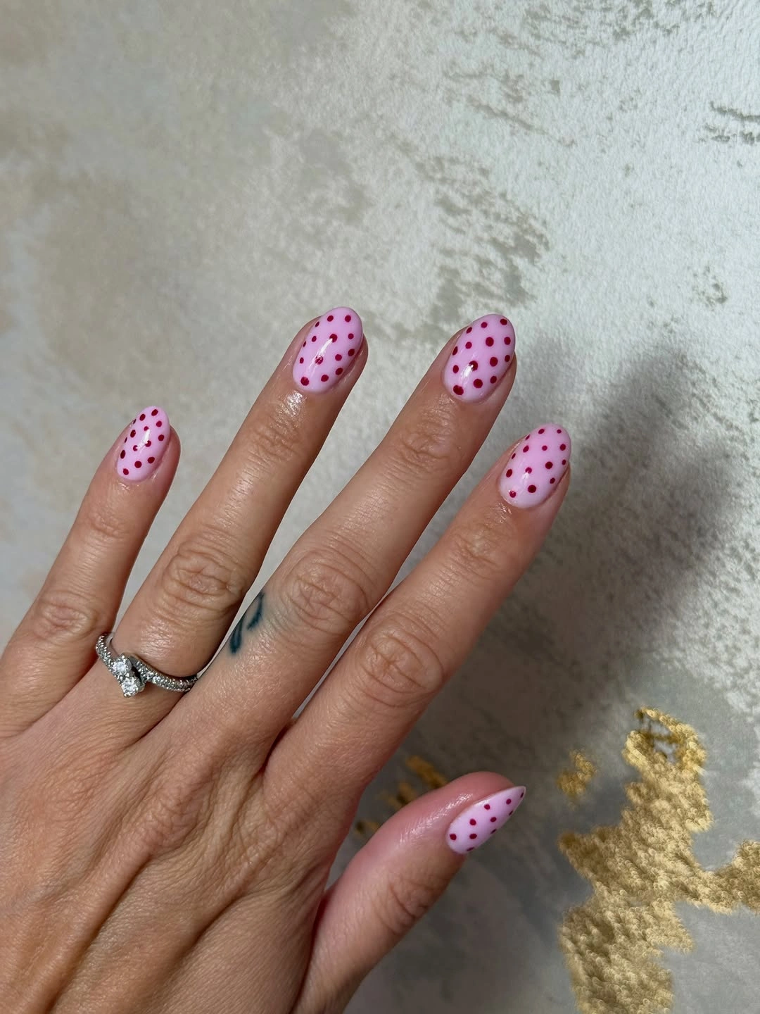 short pale pink nails with burgundy polka dots