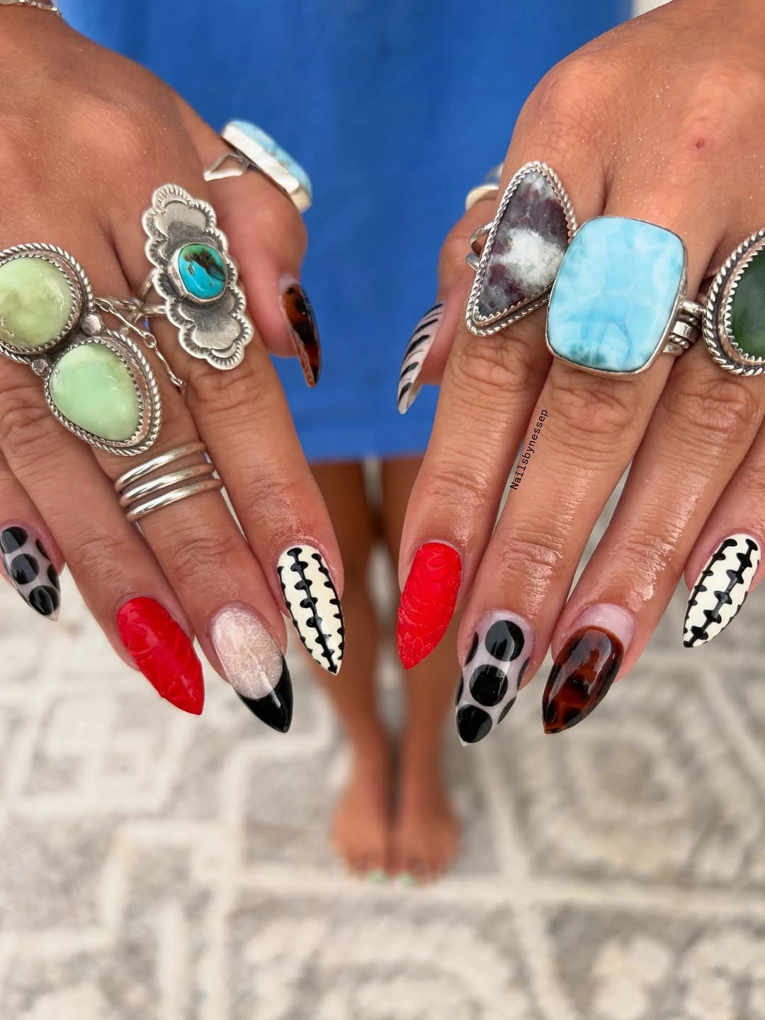 long pointed nails with red black white nude and brown dotted graphic designs
