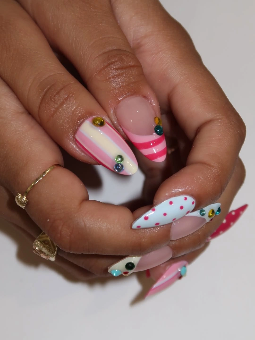 multicolor almond nails with stripes polka dots and small gem accents
