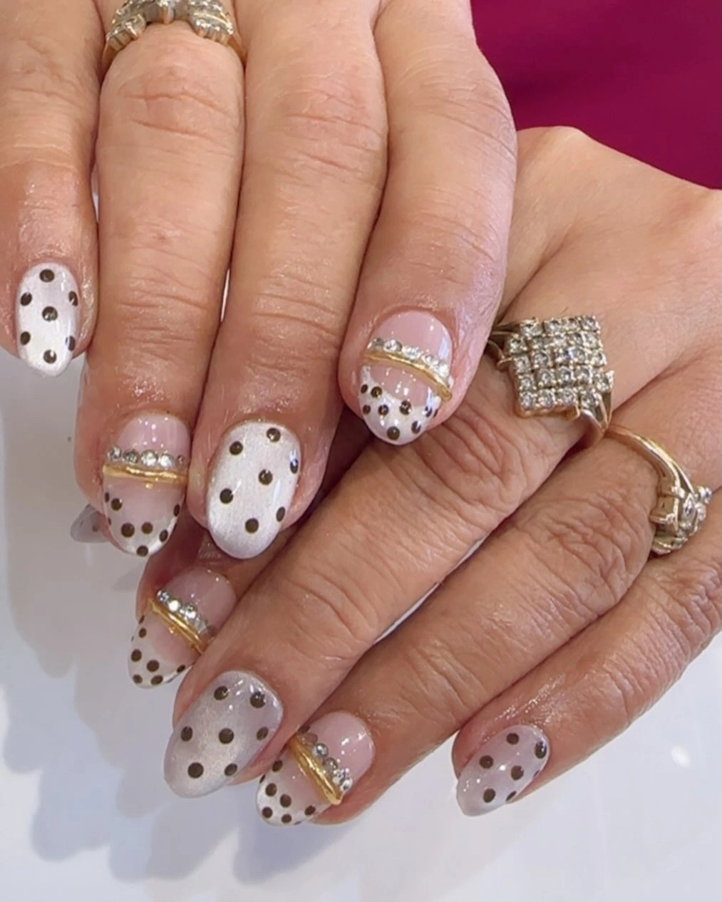 milky white almond nails with small dots and fine gold curved details