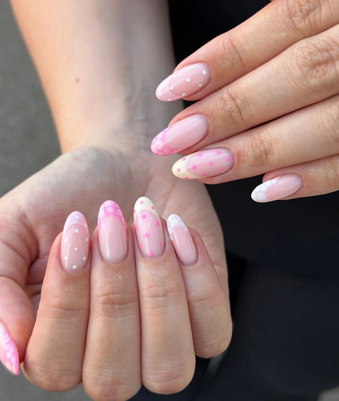 pink almond nails with white dots and layered pink tip details