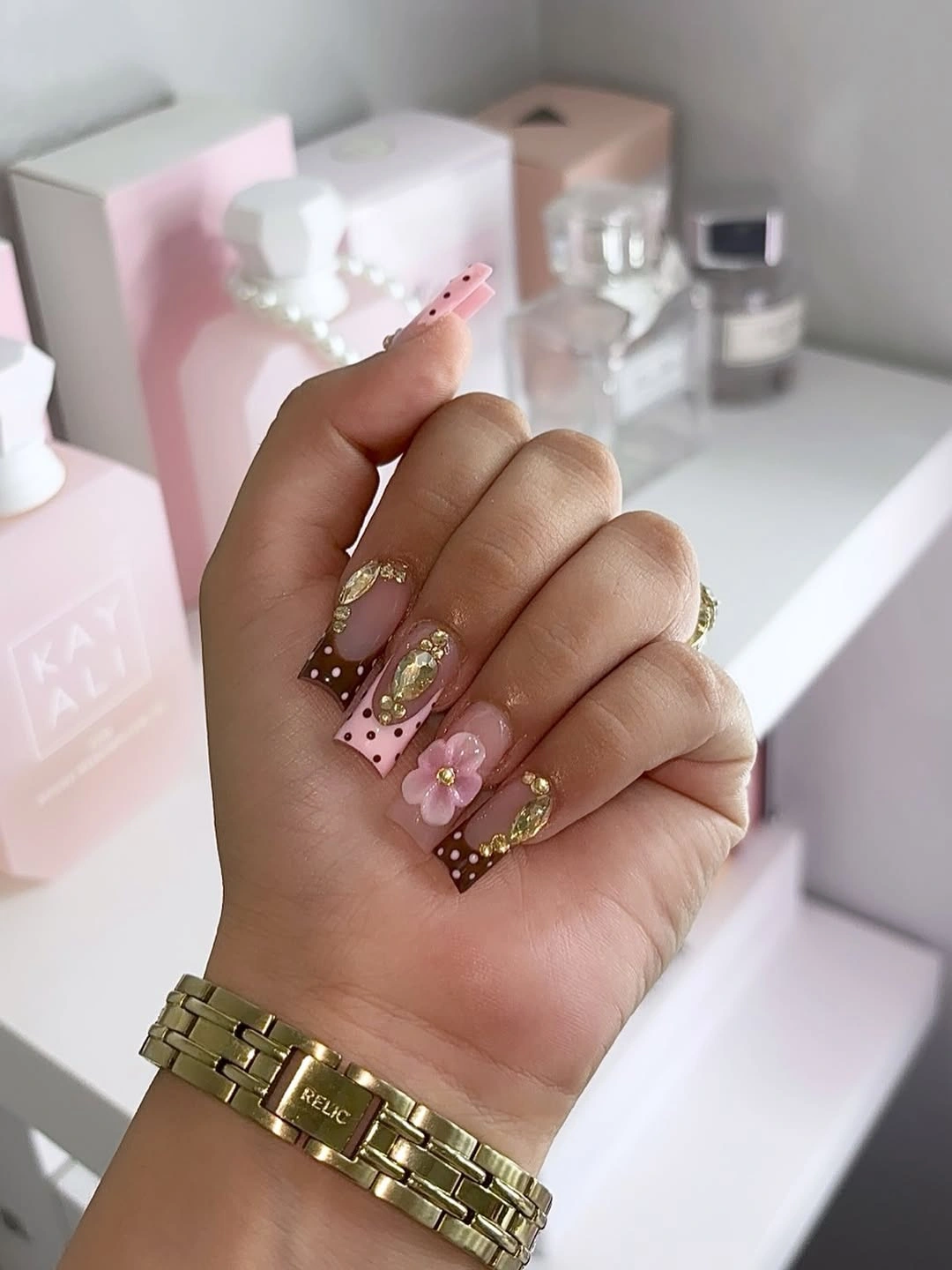 chocolate brown and pink nails with polka dots floral accents and gold details