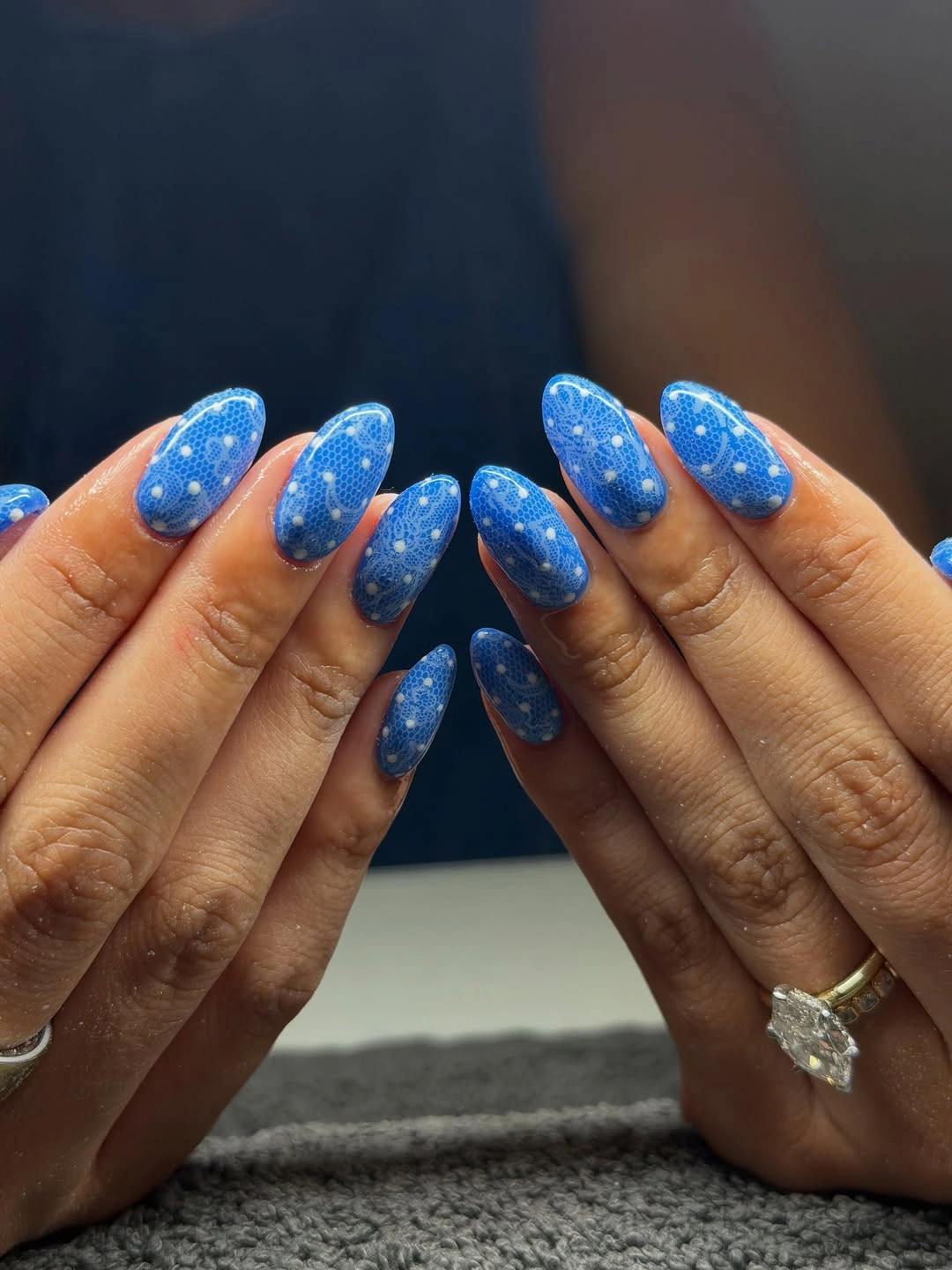 bright blue almond nails with small pale polka dots