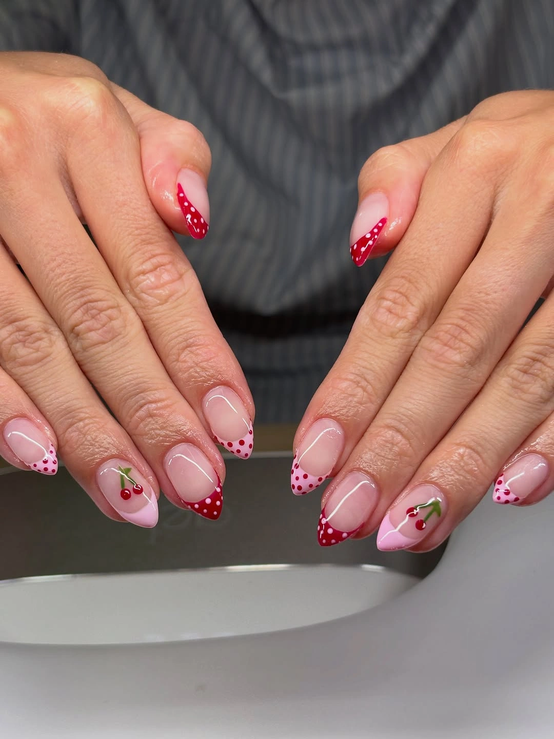 pink almond nails with red French tips dots and cherry accents