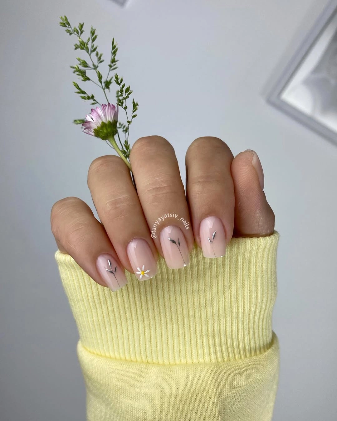 Nude pink rounded nails with tiny floral stem details