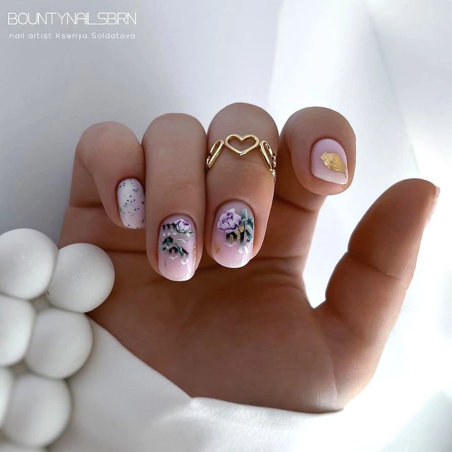Short pale pink nails with speckles, florals and gold accent