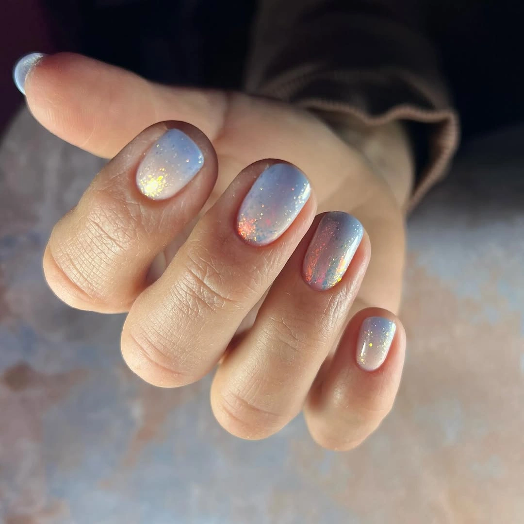 Very short rounded nails with cool shimmer and sparkling flecks