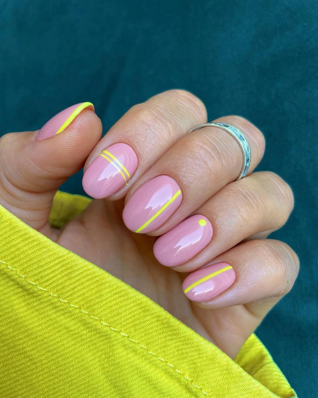 Short oval pink nails with neon yellow graphic lines