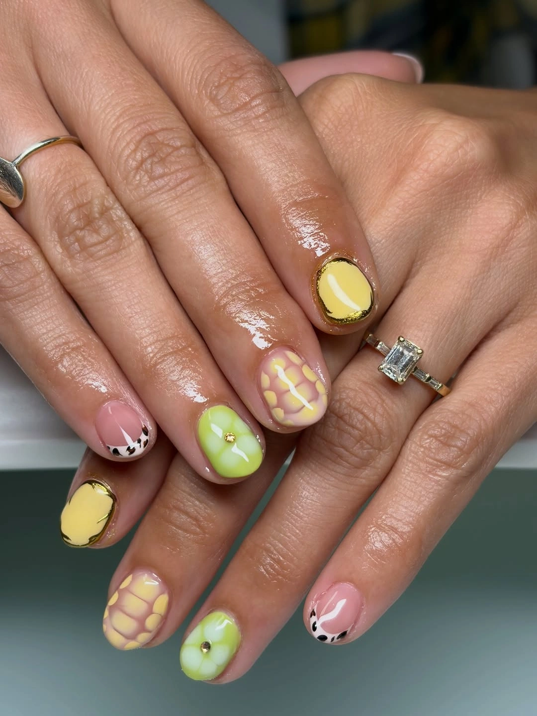 Short rounded nails with yellow, green, pink and spotted accents