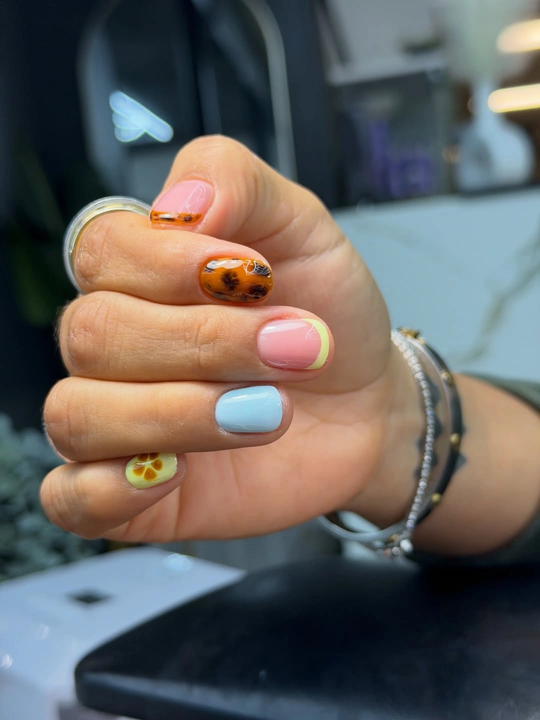 Short rounded nails with pastels, tortoiseshell and citrus accent