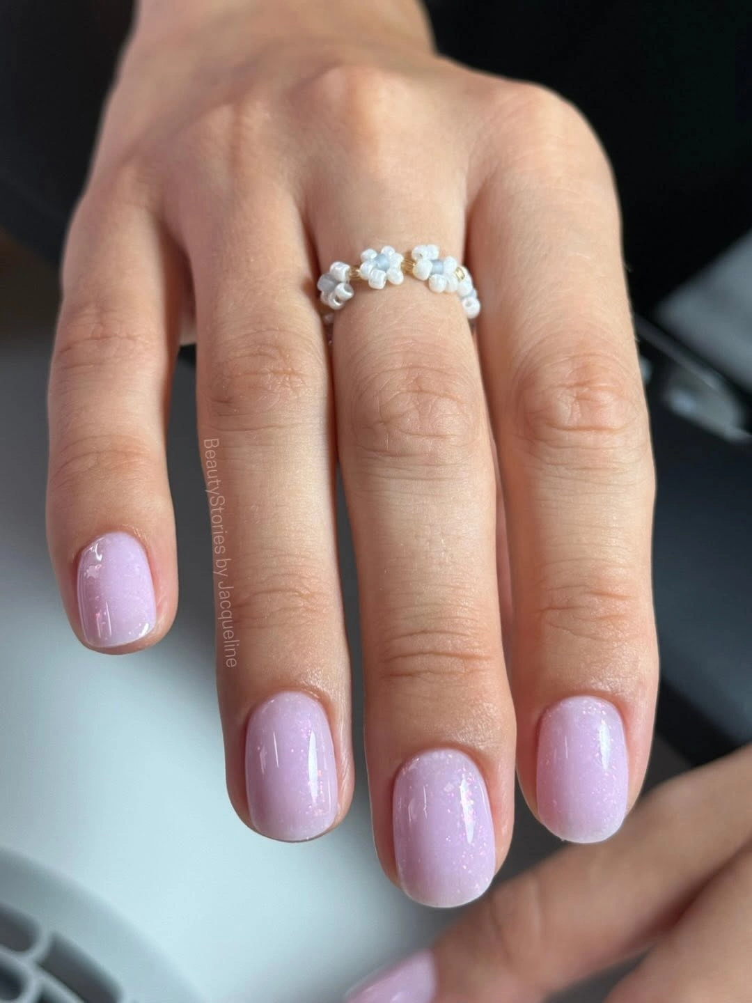 Very short rounded lilac pink nails with subtle shimmer