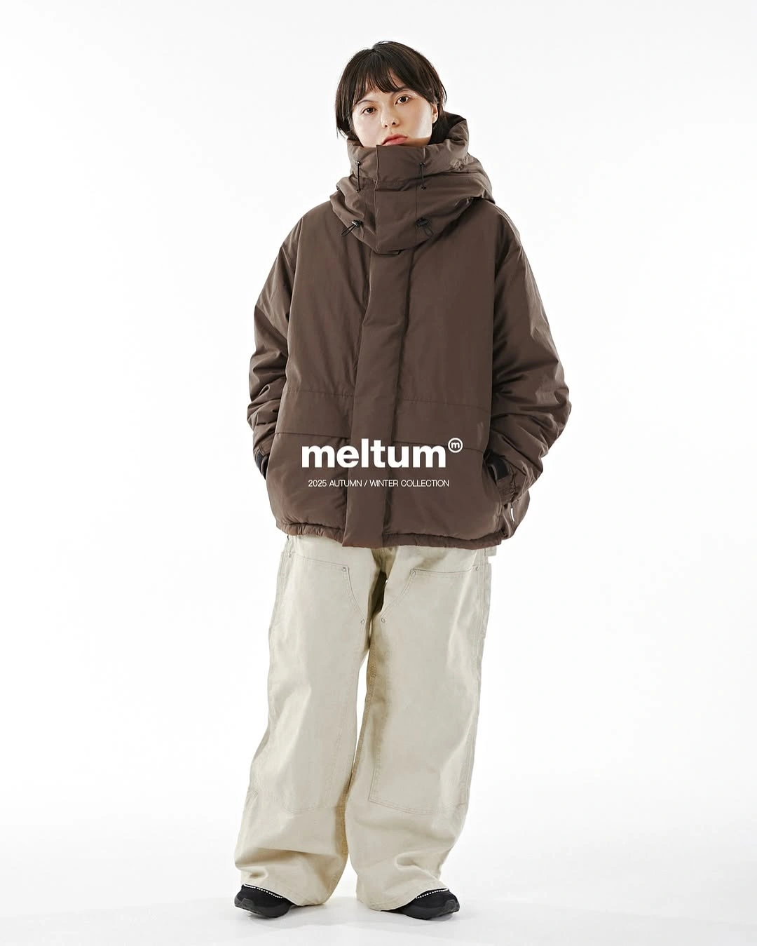 oversized taupe hooded puffer with cream wide trousers and black shoes