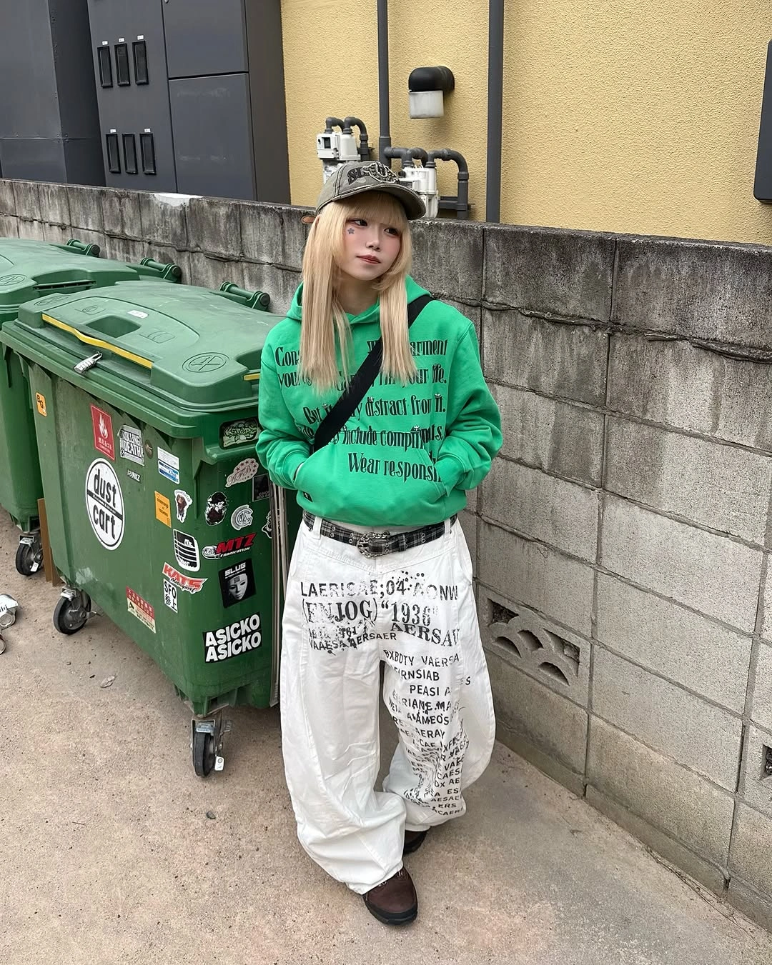 bright green oversized hoodie with white graphic trousers cap and dark shoes