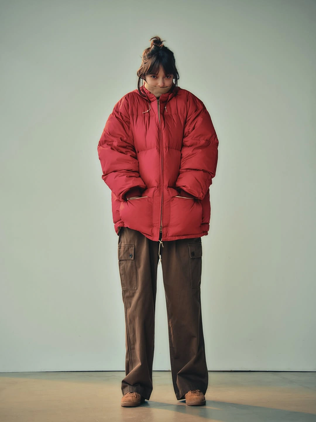 bright red puffer jacket with brown cargo trousers and dark shoes