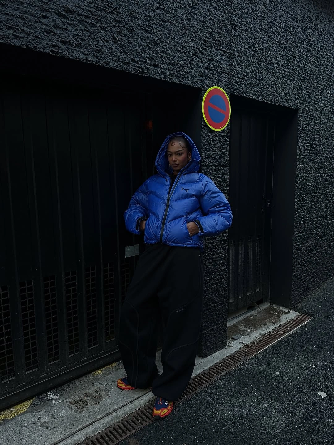 cropped cobalt puffer with wide black trousers and colorful slides