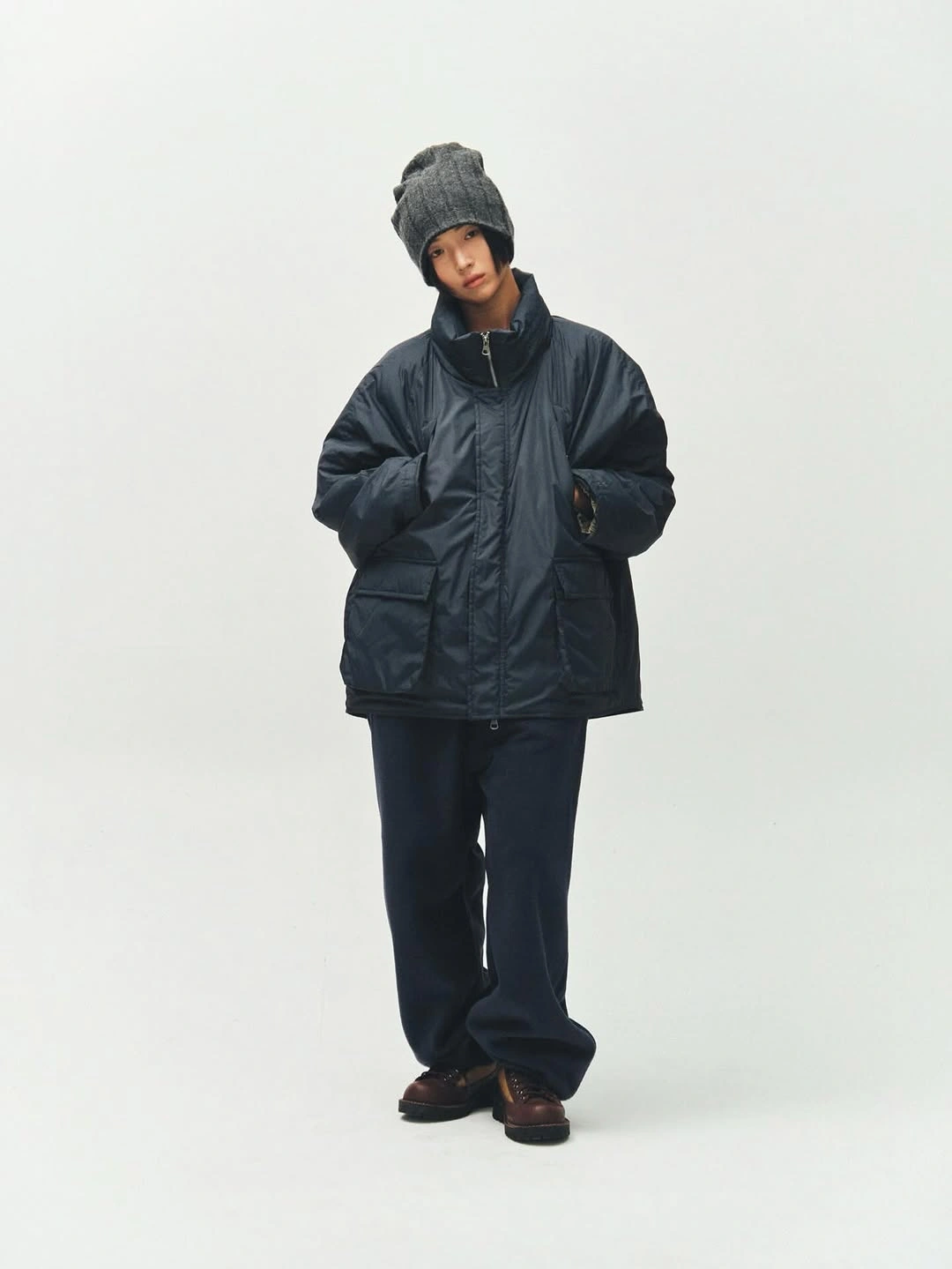 dark navy oversized puffer black beanie black trousers and brown shoes
