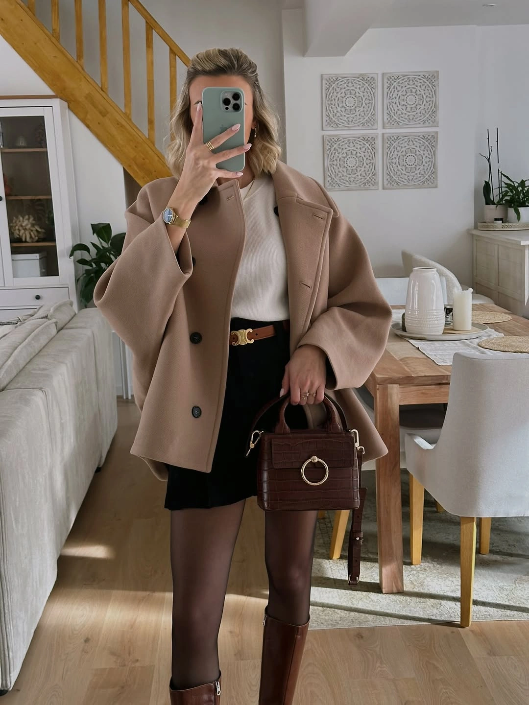 Short camel coat with dark mini-length hem and tall brown boots