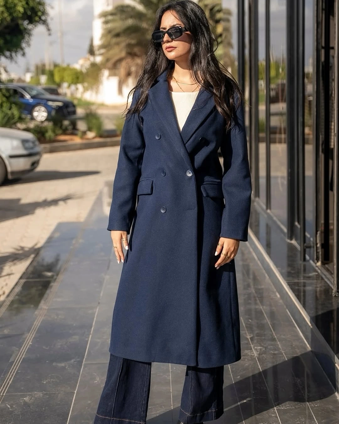 Long navy double-breasted coat with white top and wide pants