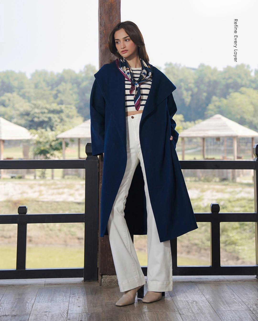 Deep navy long coat with striped top and white trousers