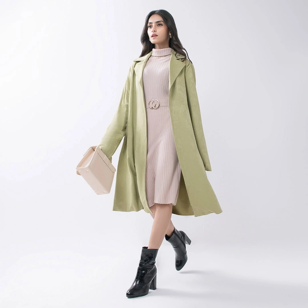 Pale green long coat with blush ribbed dress and black boots