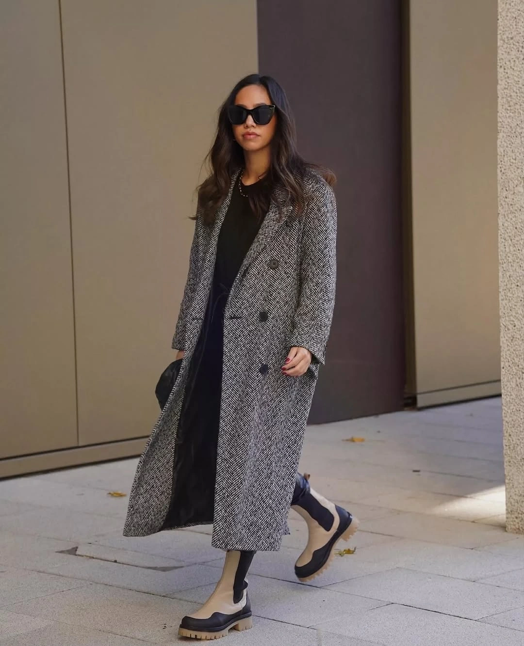 Long grey patterned coat over black layers and chunky loafers