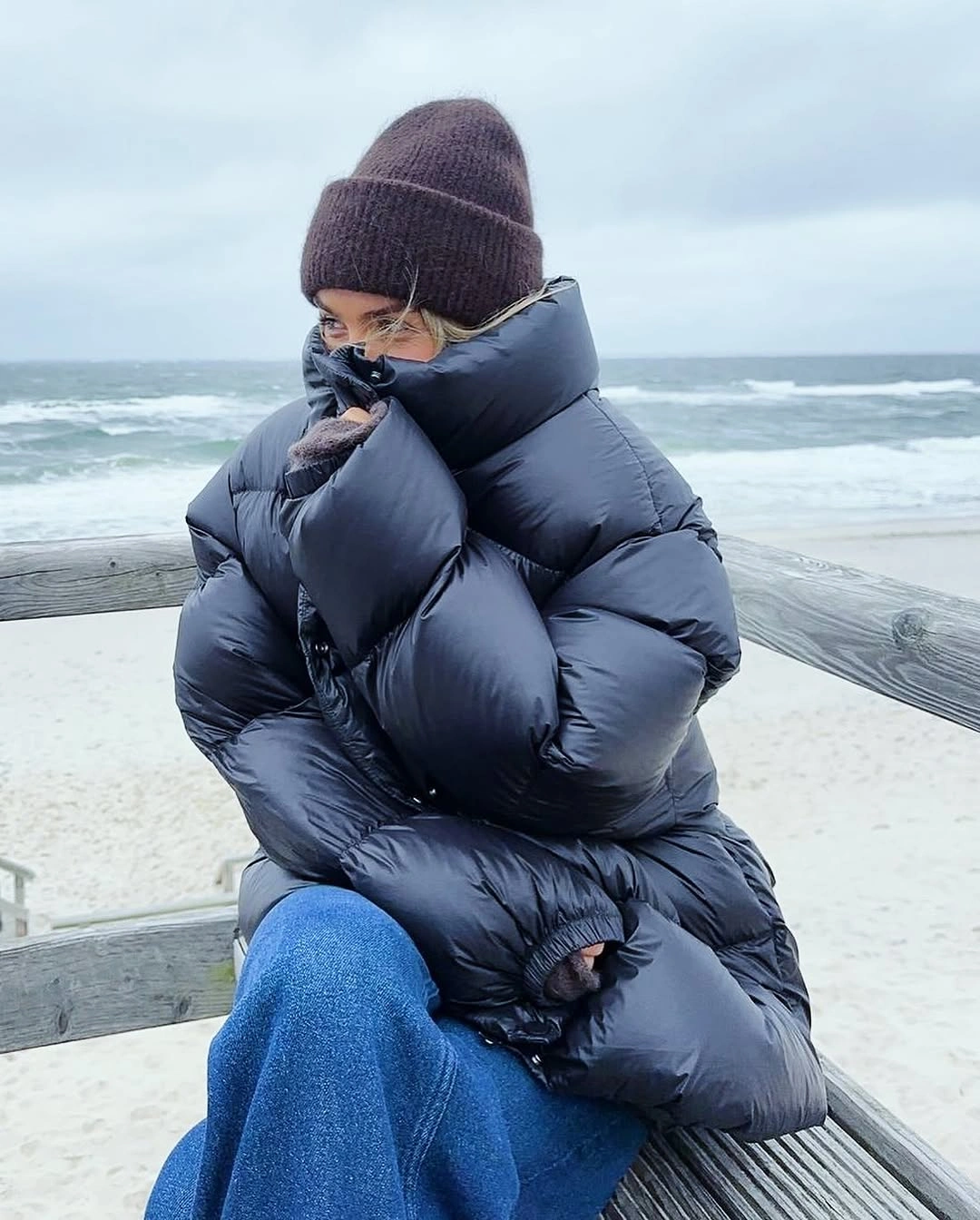Navy glossy oversized puffer with beanie and blue jeans