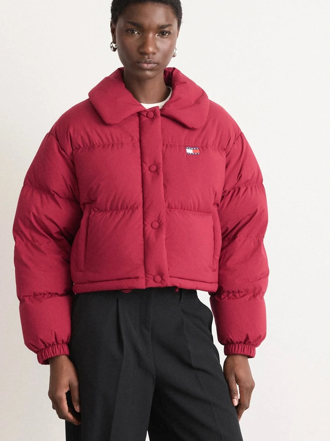 Red cropped padded jacket with black high waist trousers