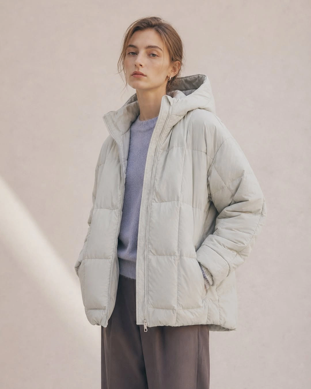 Stone gray hooded puffer with lavender top and gray trousers