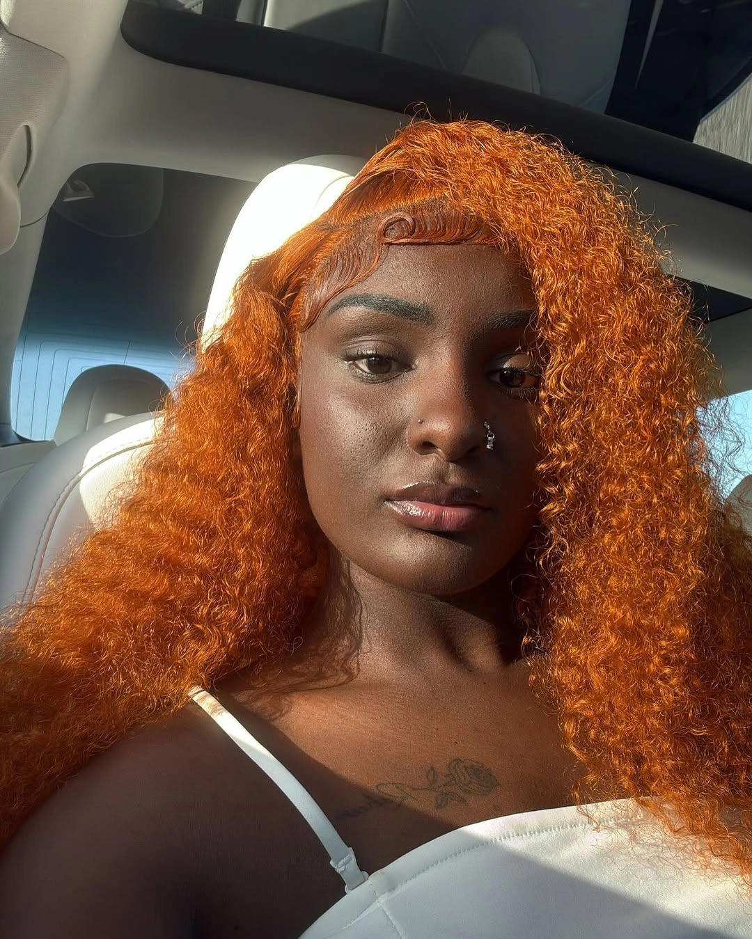 Copper-orange curls with deep side part and curved hairline detail