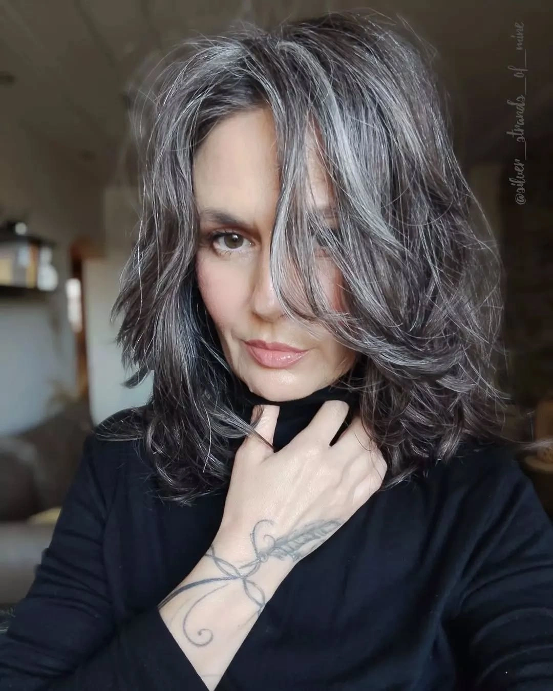 Dark medium layered hair with gray streaks and sweeping front