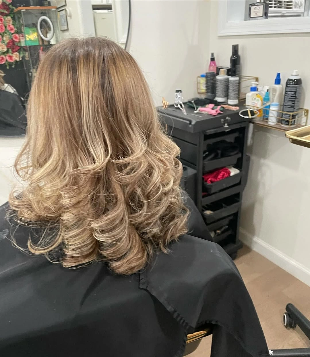 Back view of shoulder-length blonde layers with curled ends