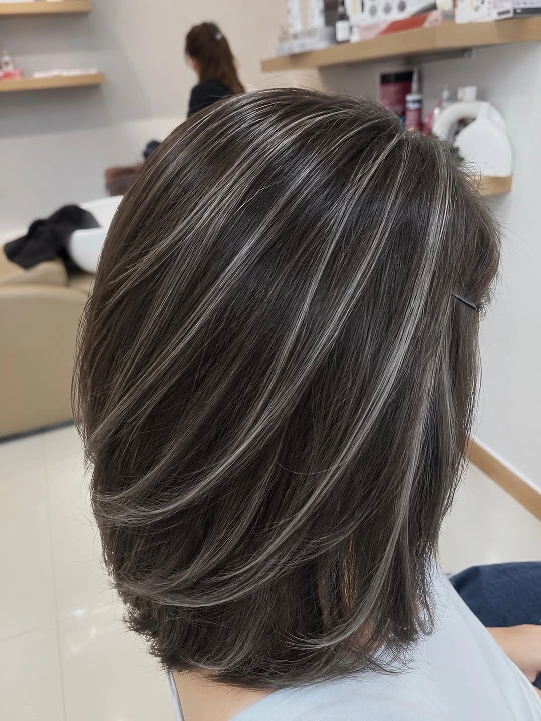 Dark gray layered short hair with diagonal sweeping sections